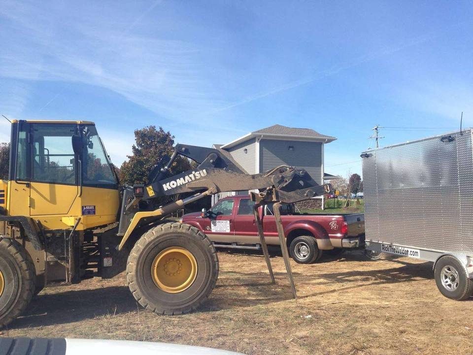 Komatsu wheel loader beside a pickup and the RickTheWelder trailer on a job site